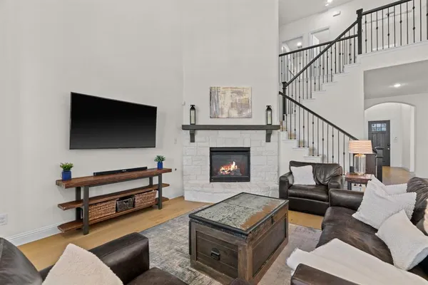 a living room with furniture a flat screen tv and a fireplace