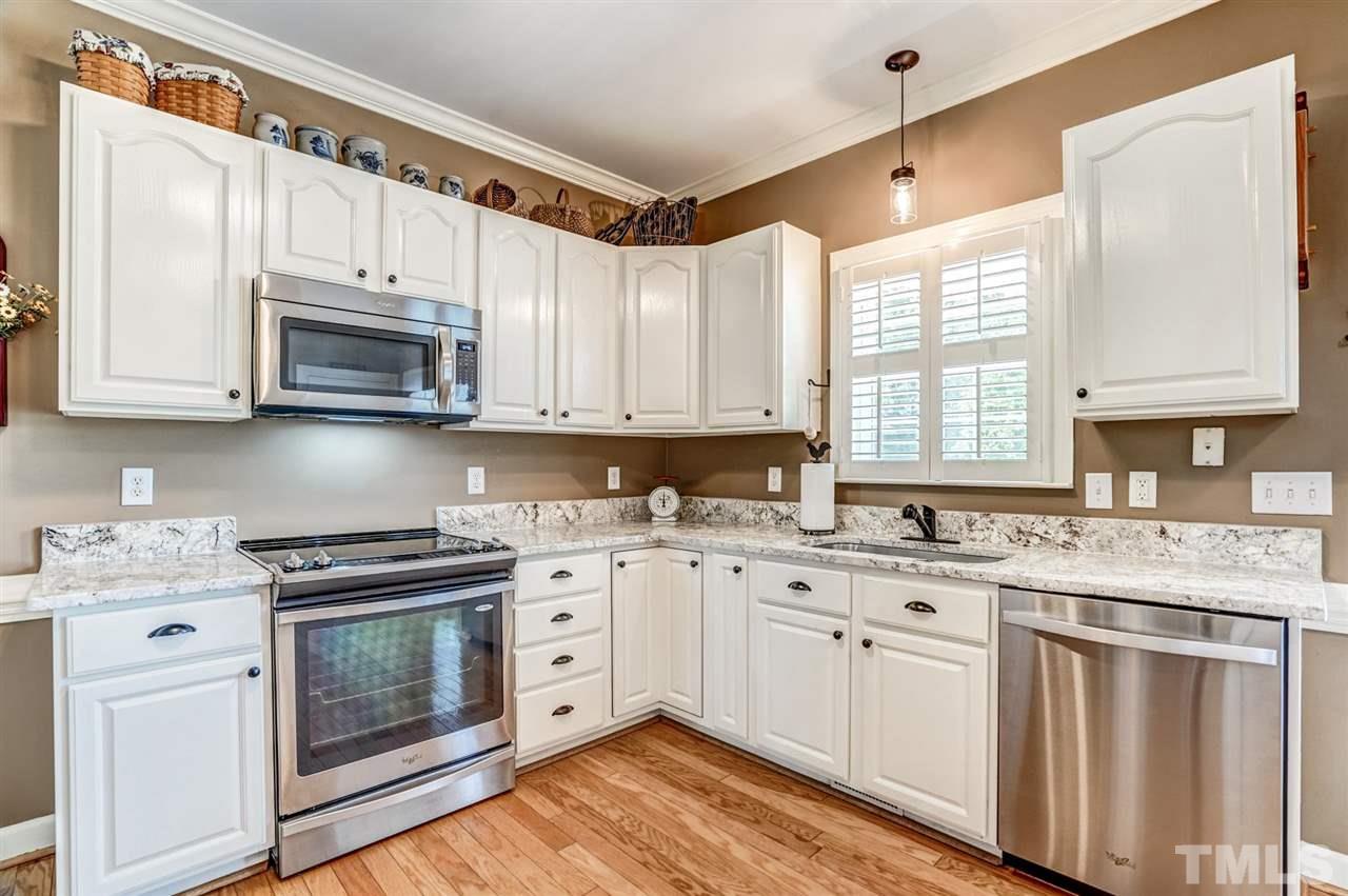 1004 Tyler Farms Drive Raleigh, NC 27603 - Photo 15 of 29 a kitchen with stainless steel appliances granite countertop a sink a stove and cabinets with wooden floor