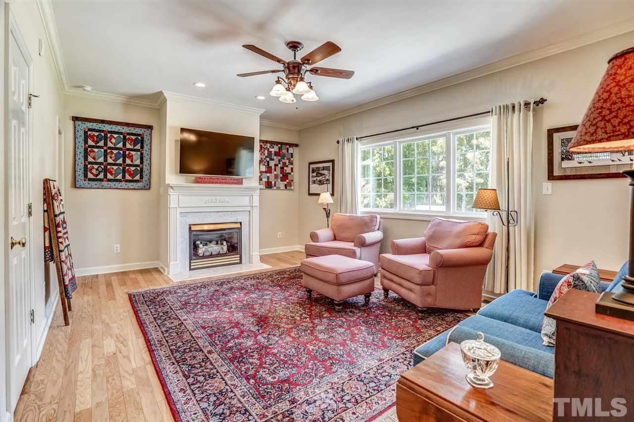 1004 Tyler Farms Drive Raleigh, NC 27603 - Photo 8 of 29 a living room with furniture a flat screen tv and a fireplace
