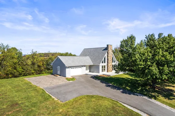 a view of a house with swimming pool and trees in the background