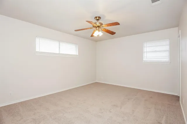 an empty room with a window and a ceiling fan