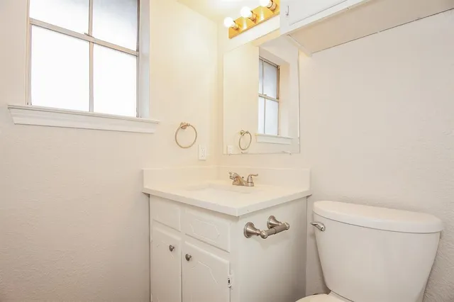 a bathroom with a sink a toilet and a mirror