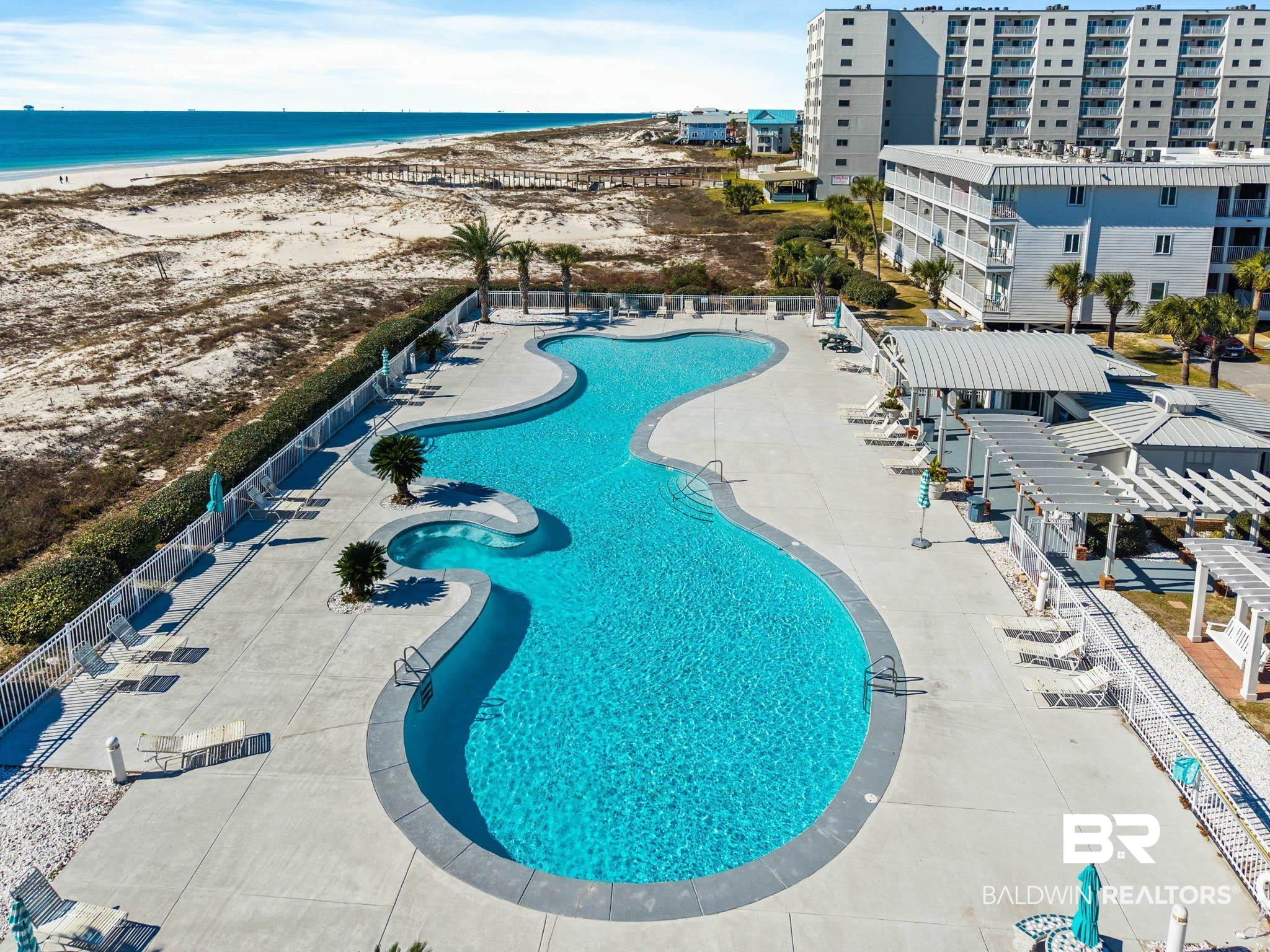 400 Plantation Road, Unit 4501 Gulf Shores, AL 36542 - Photo 3 of 30 Expansive serpentine swimming pool with integrated spa, surrounded by a paved deck