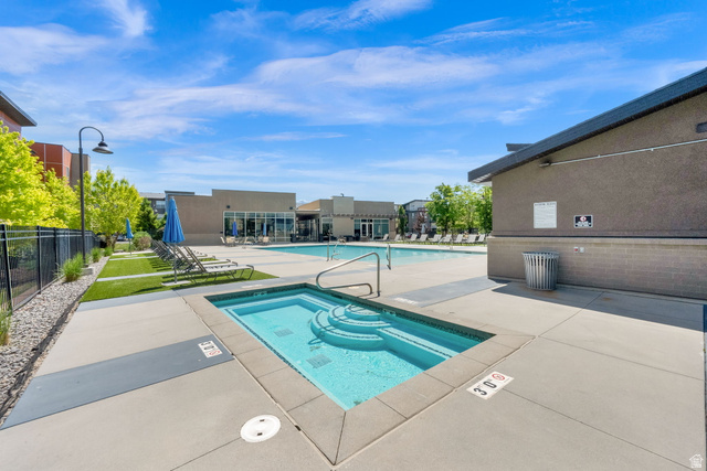 7713 Navarro View Court Midvale, UT 84047 - Photo 30 of 41 Pool area featuring a hot tub with integrated steps, a large swimming pool, and a surrounding concrete deck