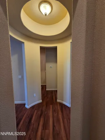 an empty room with wooden floor cabinet and windows