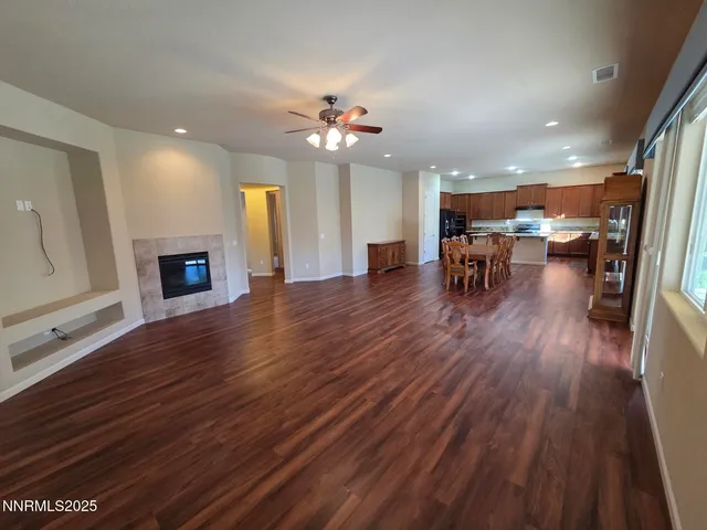 a kitchen with kitchen island granite countertop wooden floors a stove and a sink