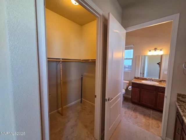 a bathroom with a granite countertop sink and a wooden cabinets