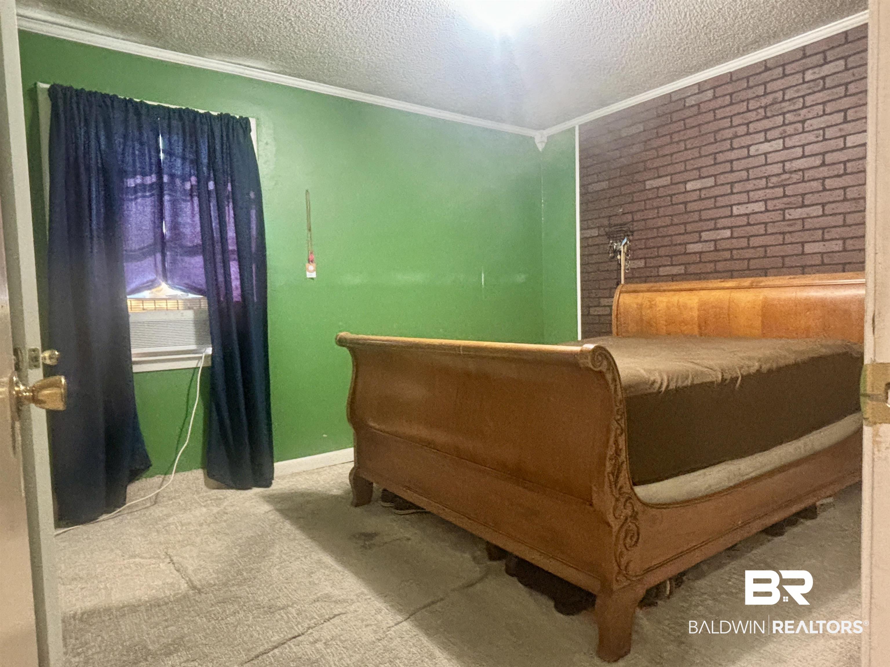 320 South Pecan Street Foley, AL 36535 - Photo 8 of 17 Carpeted bedroom featuring ornamental molding and a textured ceiling