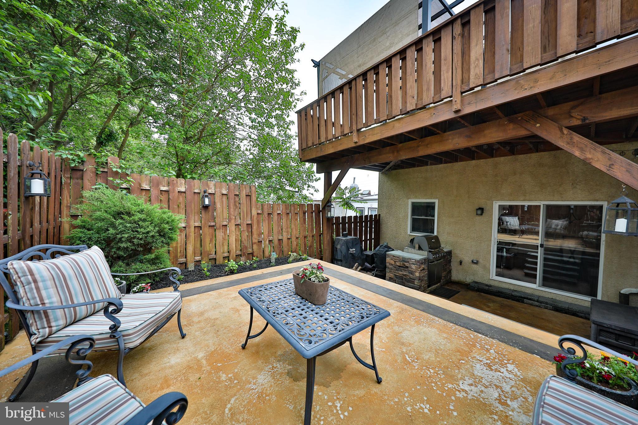 a backyard of a house with barbeque oven and outdoor seating