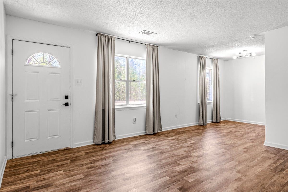 5626 Lamb Road Arlington, TN 38002 - Photo 6 of 33 a view of an empty room with wooden floor and a window