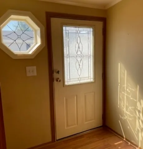 a view of entryway with wooden floor and a front door