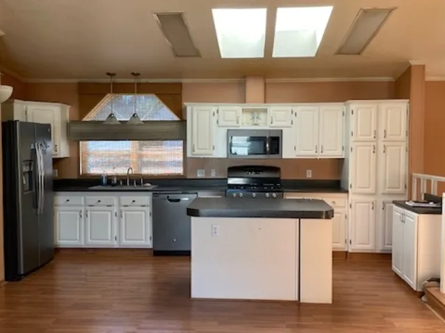 a kitchen with stainless steel appliances a stove a sink and a refrigerator