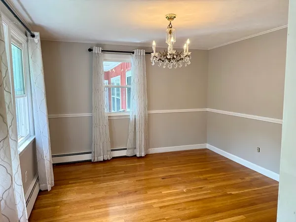 a view of a room with wooden floor and chandelier