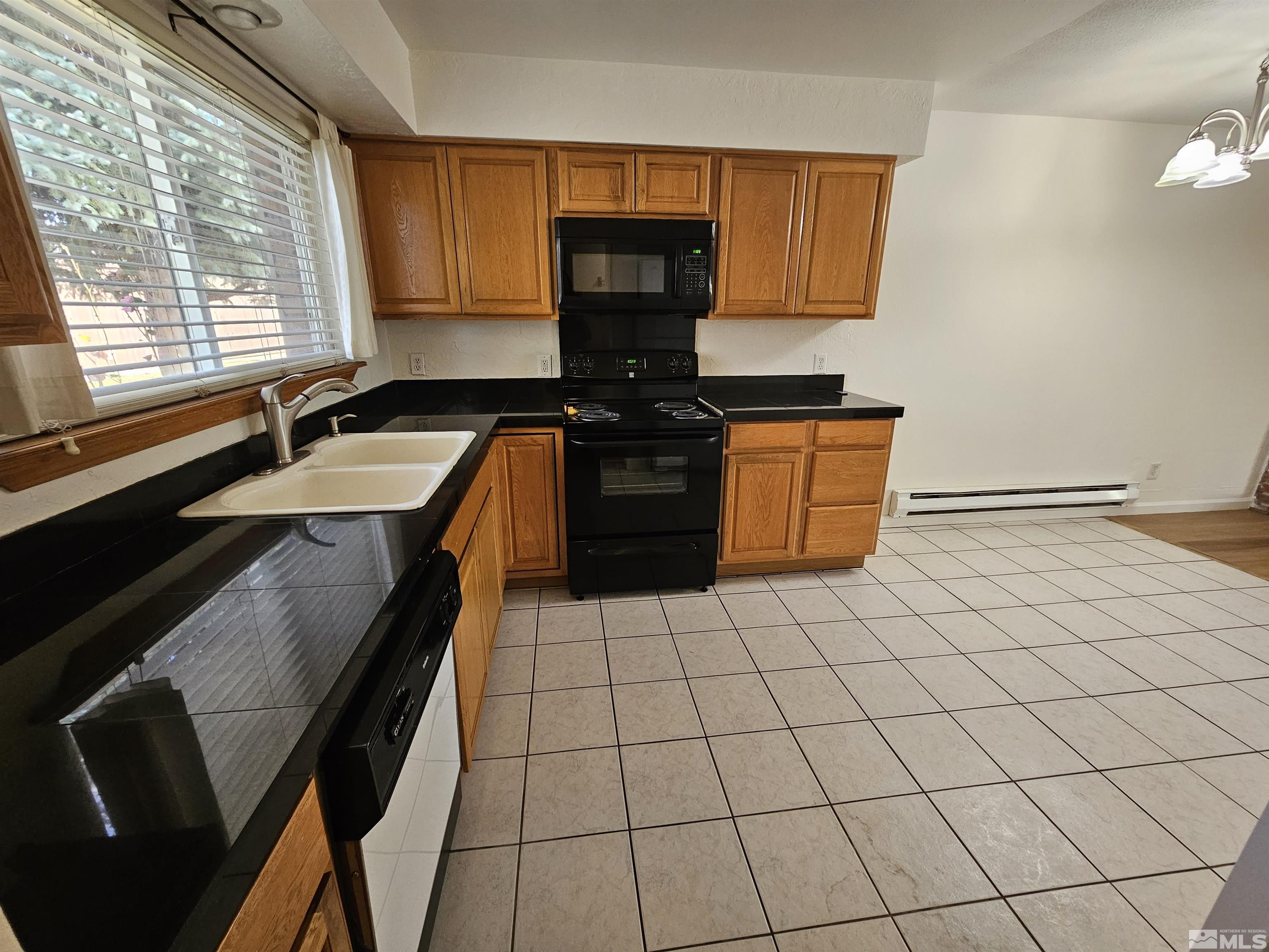 163 Smithridge Park Reno, NV 89502 - Photo 5 of 28 a kitchen with granite countertop a stove a sink and a microwave