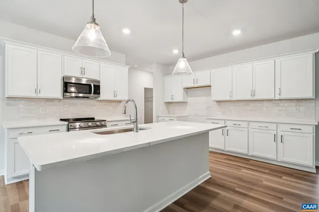 a kitchen with kitchen island a stove a sink a center island and cabinets