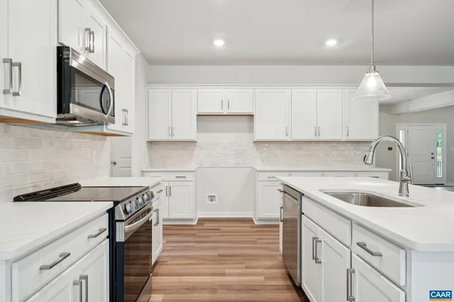 a kitchen with stainless steel appliances granite countertop a sink and a stove