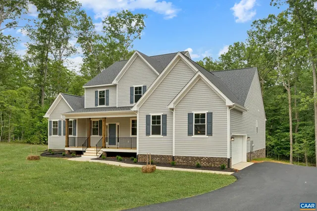 a view of house with a yard and sitting area