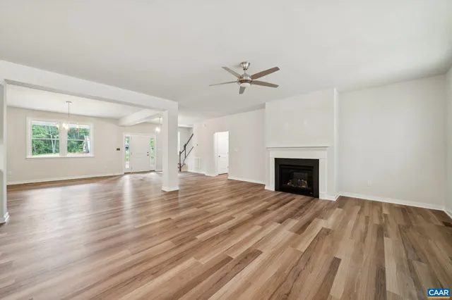 a view of empty room with wooden floor and fireplace