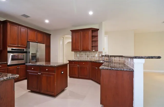 a kitchen with stainless steel appliances granite countertop wooden cabinets a stove top oven a sink and dishwasher