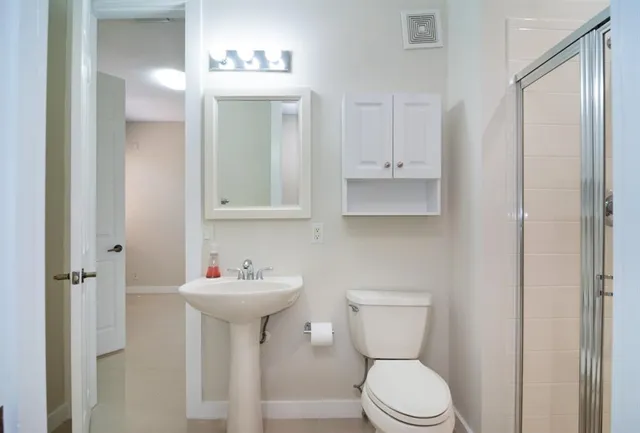 a bathroom with a sink a toilet and mirror