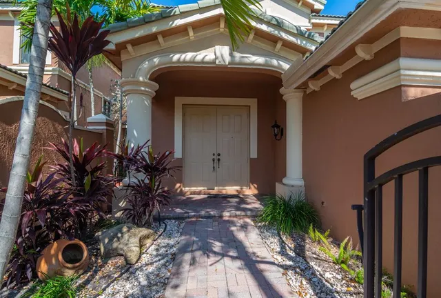 a view of a house with a small yard and potted plants