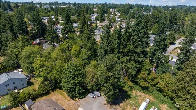 an aerial view of residential house with outdoor space and trees all around