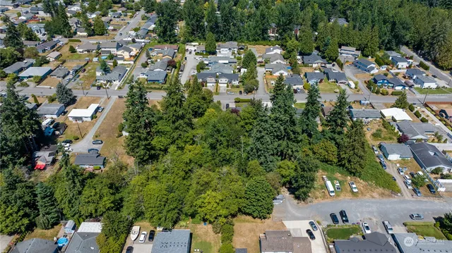 an aerial view of residential houses with outdoor space and trees all around