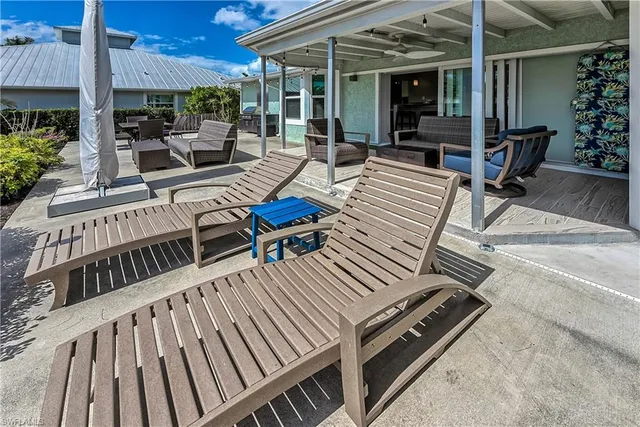 a view of a patio with table and chairs with wooden floor and fence