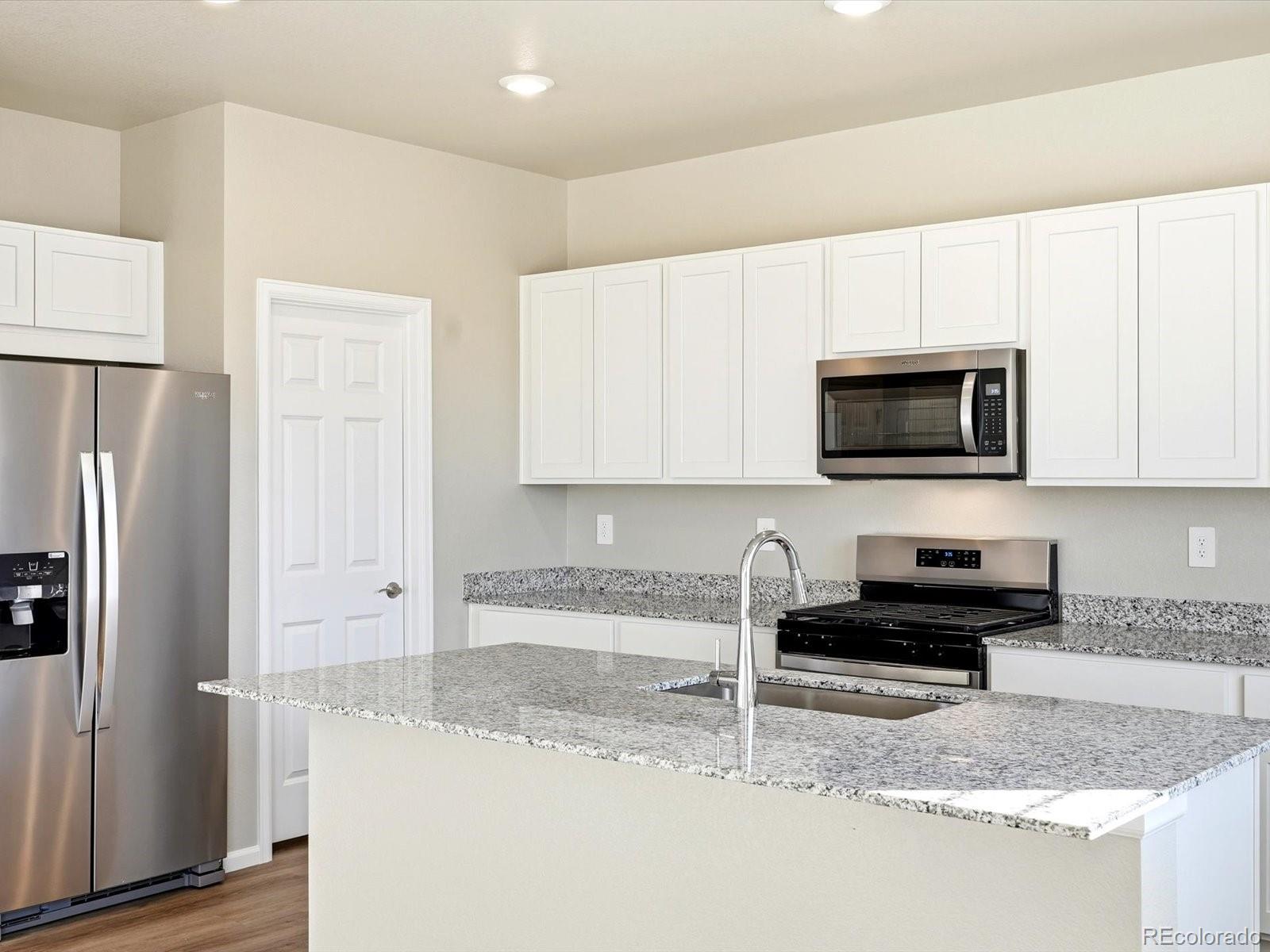 7317 West 27th St Road Greeley, CO 80634 - Photo 1 of 28 a kitchen with granite countertop a refrigerator a stove a microwave and cabinets