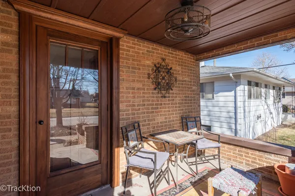 a patio with table and chairs and potted plants