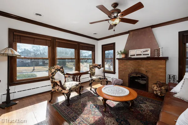 a living room with furniture a fireplace and a large window