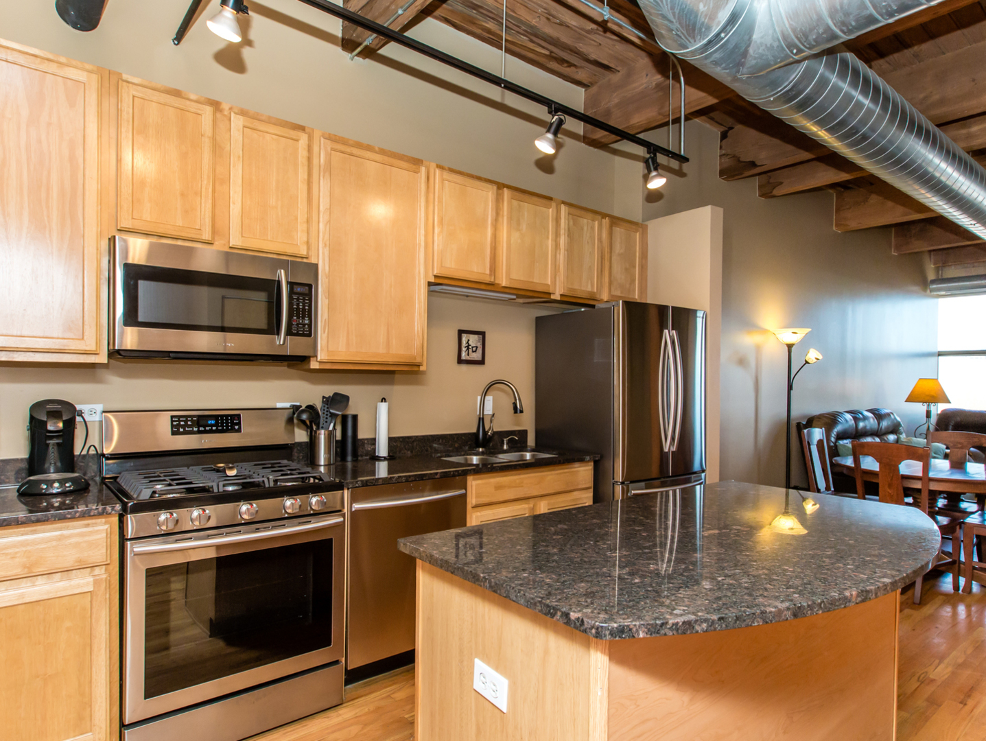 1500 West Monroe Street, Unit 524 Chicago, IL 60607 - Photo 8 of 20 a kitchen with stainless steel appliances granite countertop a sink a stove and microwave