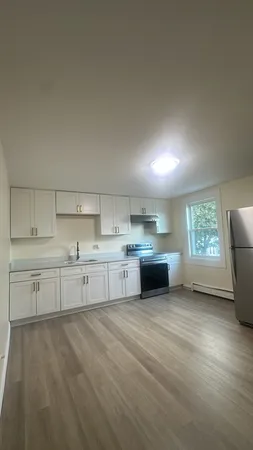 a kitchen with stainless steel appliances a sink cabinets and wooden floor