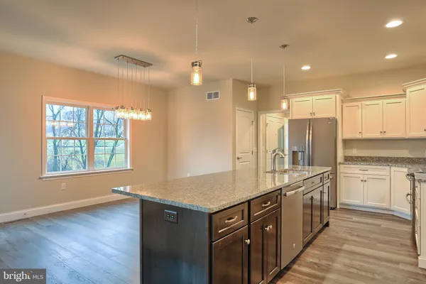 a kitchen with stainless steel appliances granite countertop a sink stove and cabinets