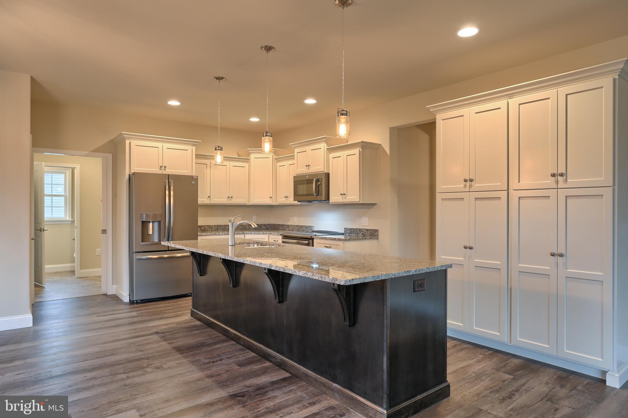 26 Rolling Meadow Road Lebanon, PA 17046 - Photo 16 of 29 a kitchen with stainless steel appliances granite countertop a refrigerator a sink a stove and white cabinets with wooden floor
