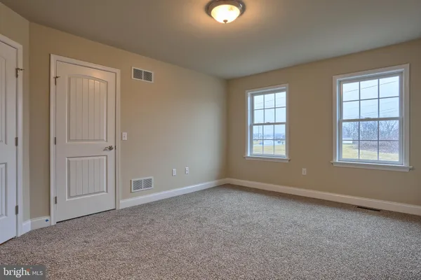an empty room with windows and closet