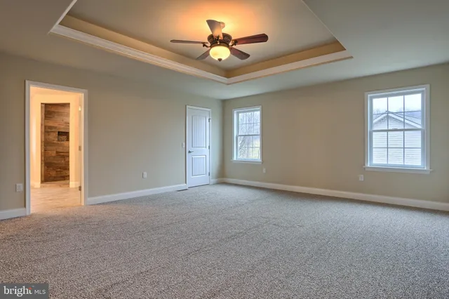 a view of a room with a ceiling fan and window