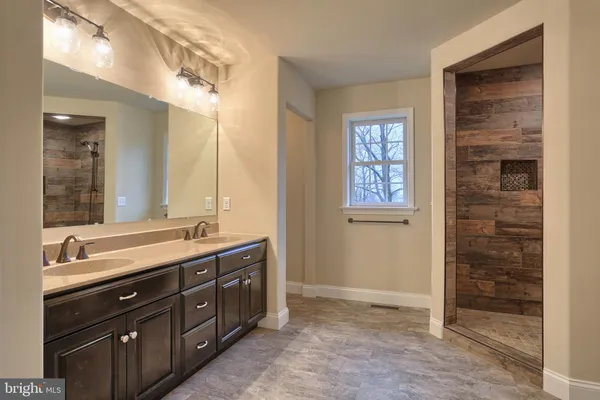 a spacious bathroom with double vanity and a mirror