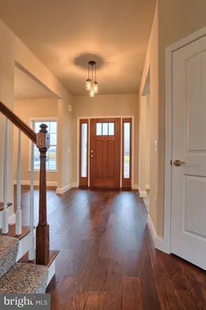 a view of a livingroom with wooden floor and large windows