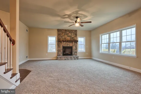 an empty room with windows and fireplace