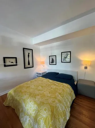 a bed sitting in a bedroom and a night stand