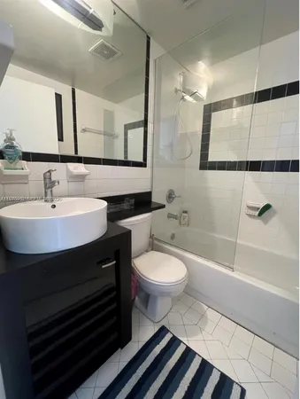 a bathroom with a sink toilet a mirror and shower