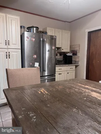 a kitchen with granite countertop a refrigerator and a stove top oven