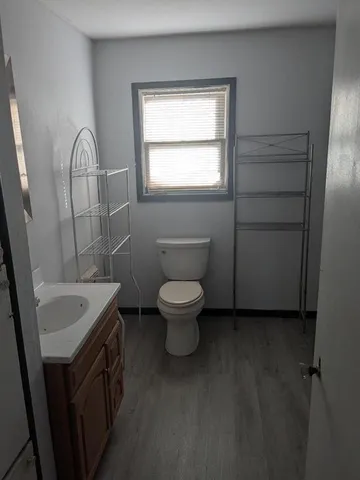 a bathroom with a toilet sink and mirror
