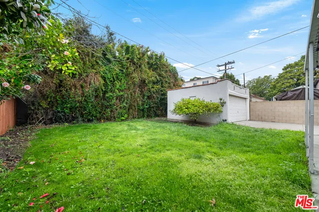 a backyard of a house with plants and outdoor seating