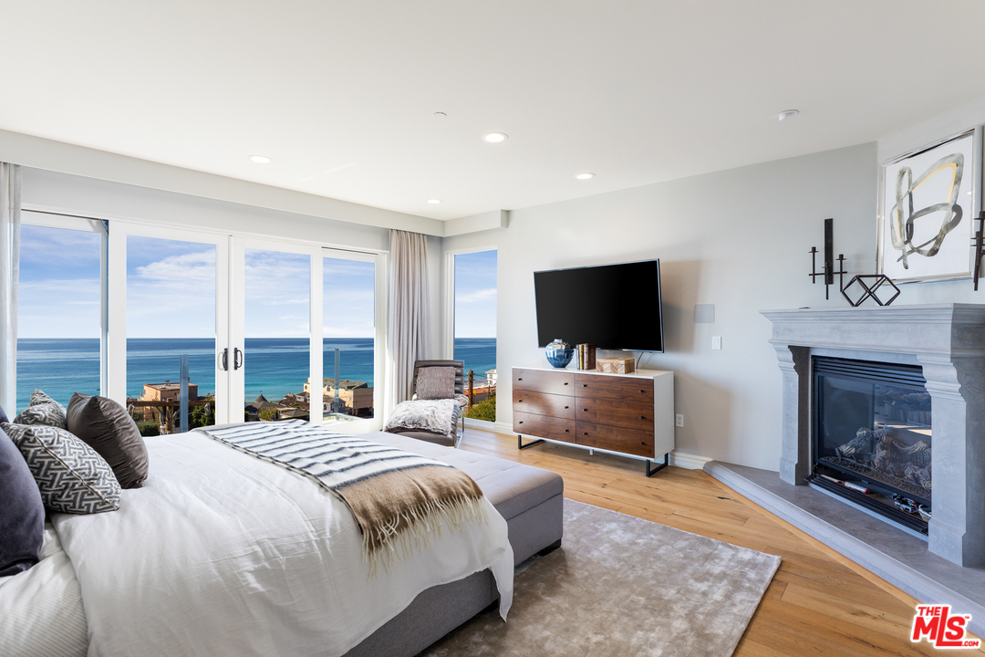 21370 Rambla Vista Malibu, CA 90265 - Photo 14 of 22 a bedroom with a bed and a flat screen tv