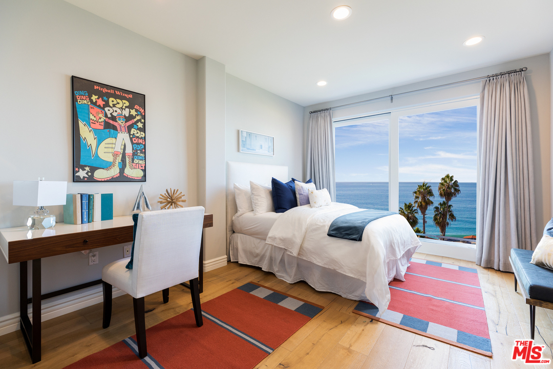 21370 Rambla Vista Malibu, CA 90265 - Photo 18 of 22 a bedroom with a bed a painting on the wall and a potted plant