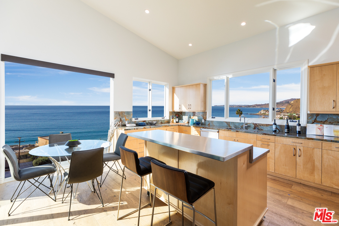21370 Rambla Vista Malibu, CA 90265 - Photo 9 of 22 a dining table with chairs and view of kitchen