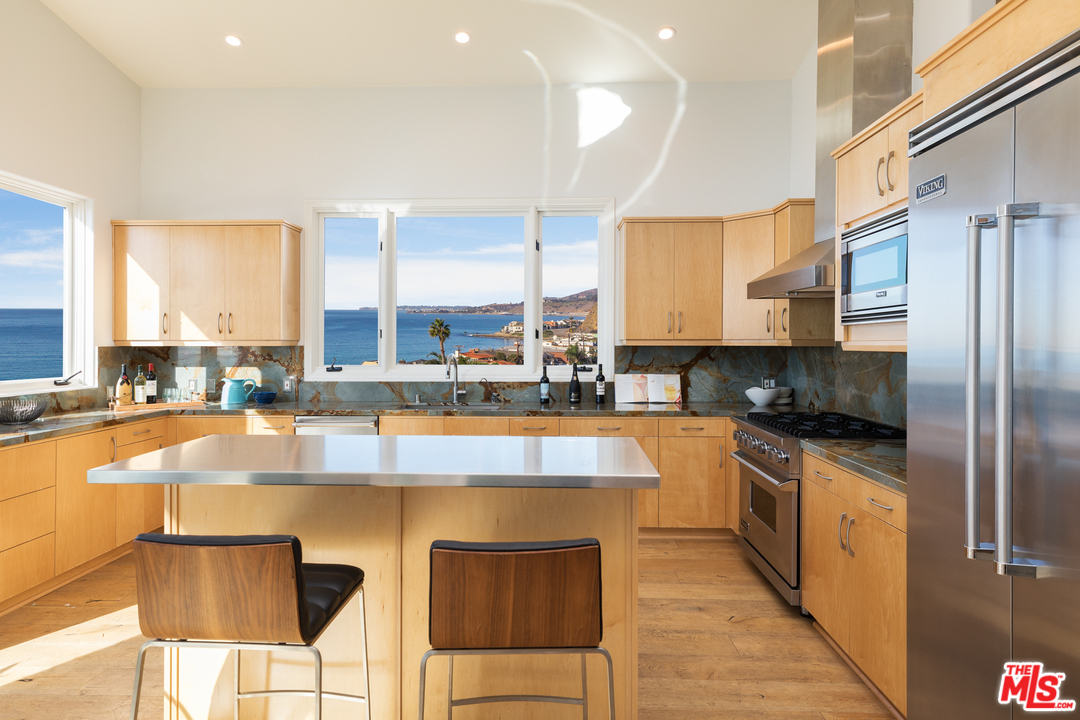 21370 Rambla Vista Malibu, CA 90265 - Photo 10 of 22 a large kitchen with stainless steel appliances granite countertop a stove a sink and a microwave