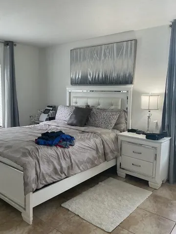 a front view of a house with a yard and potted plants